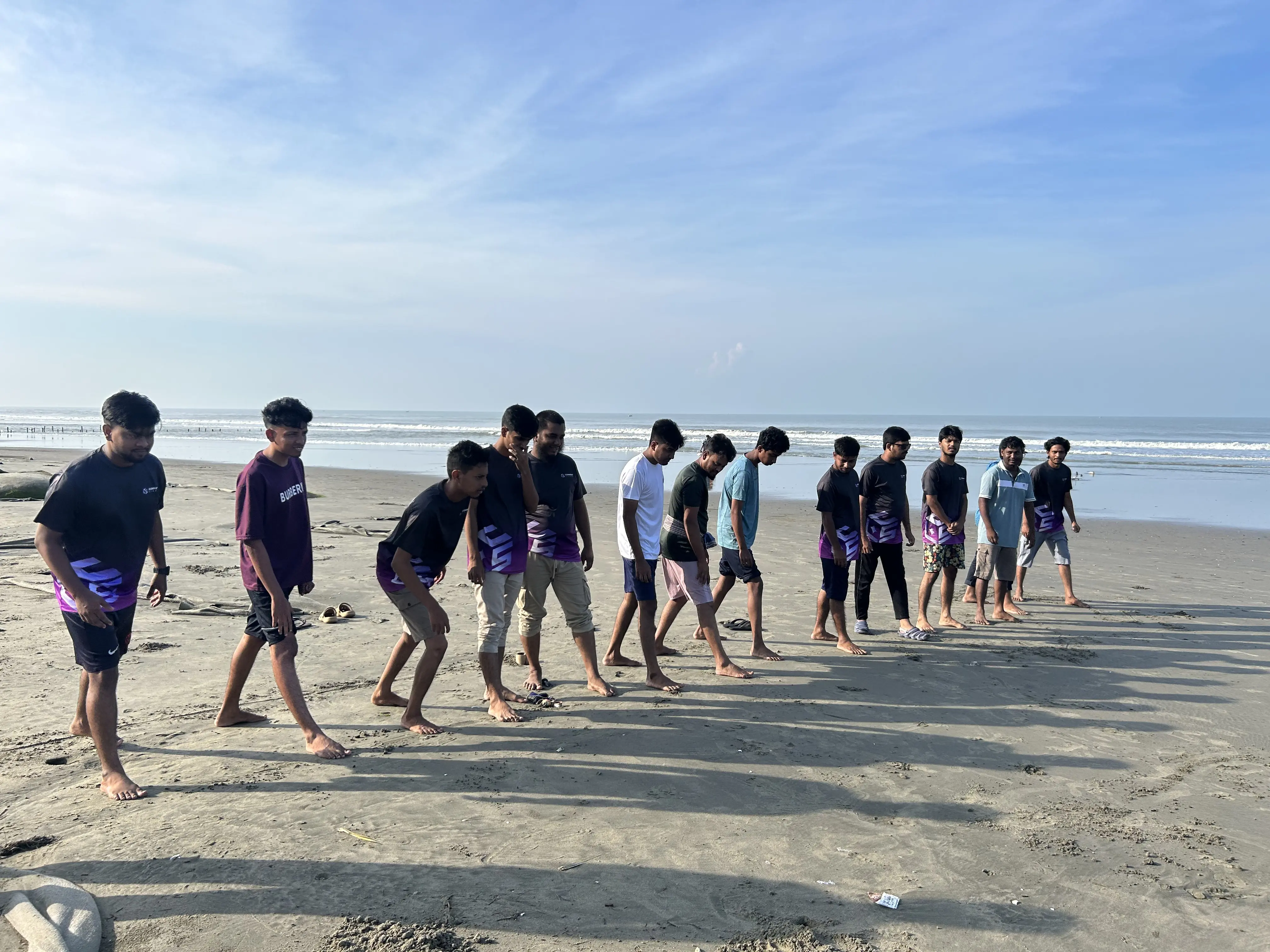 Team members participating in an energetic running competition on the beach