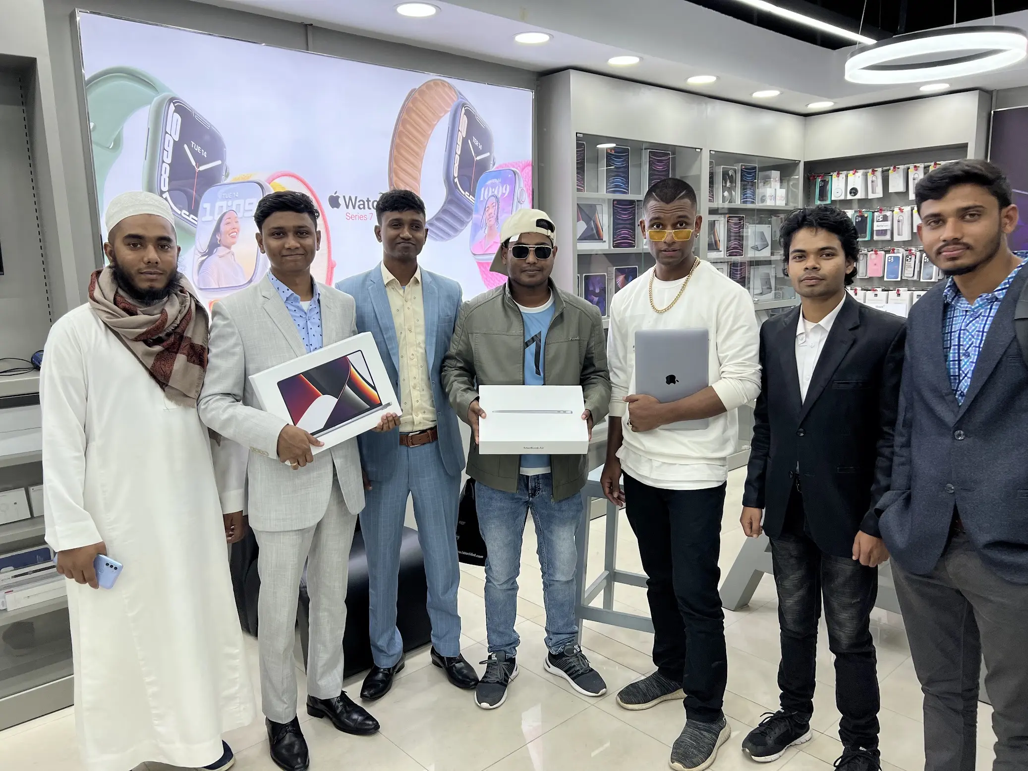 Team celebrating new Apple device purchases at authorized store